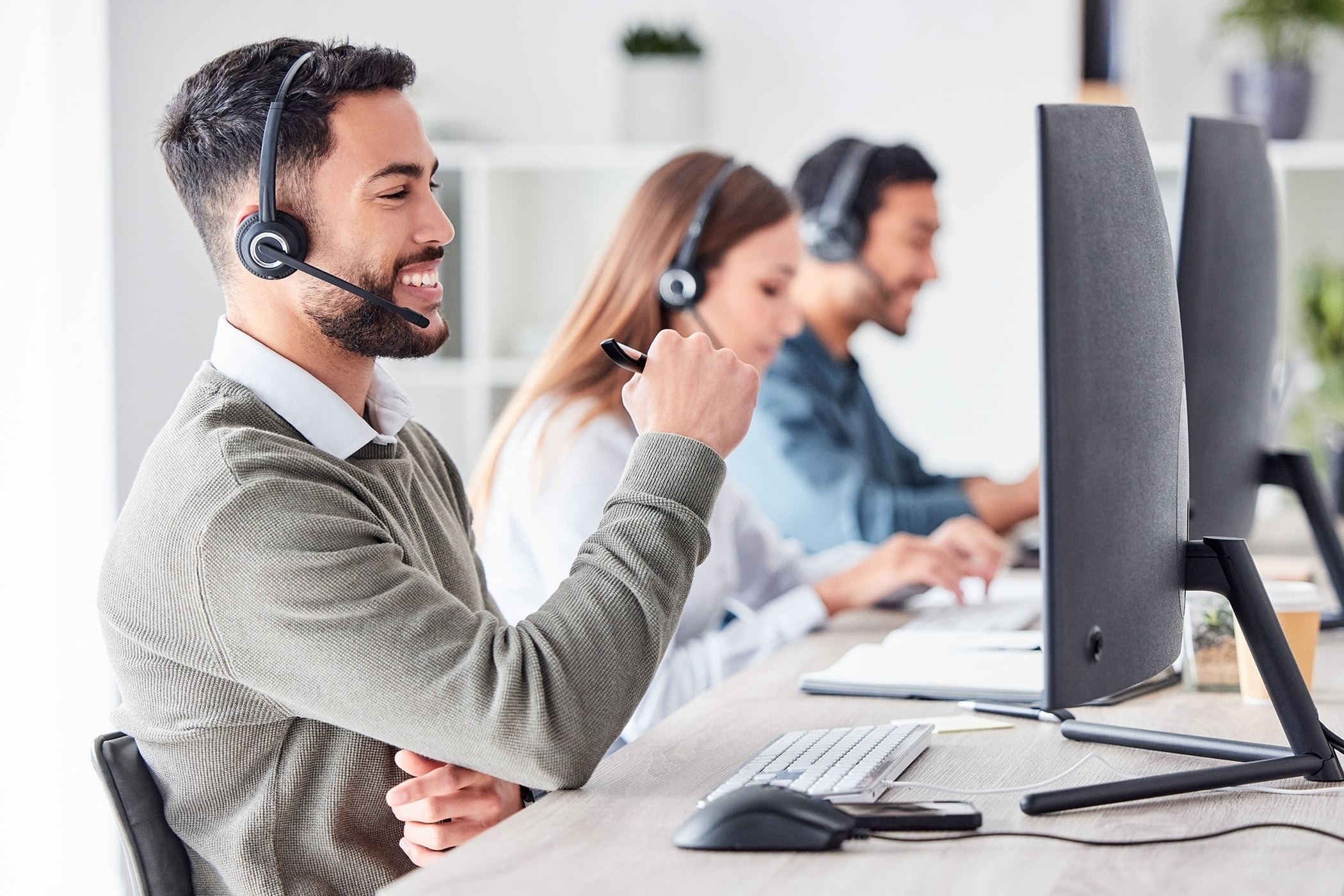 Man, call center and working in team office with headset